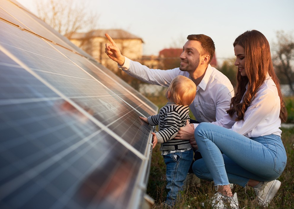 family in front of solar panels